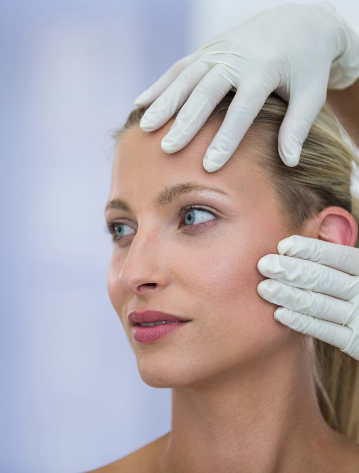 Doctor examining female patients face from cosmetic treatment